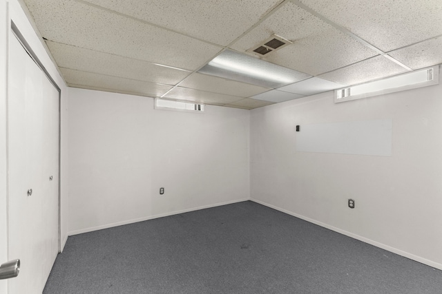 finished basement with visible vents, a paneled ceiling, baseboards, and carpet floors