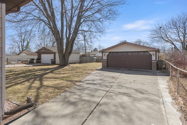 view of home's exterior with an outbuilding, brick siding, a detached garage, and fence