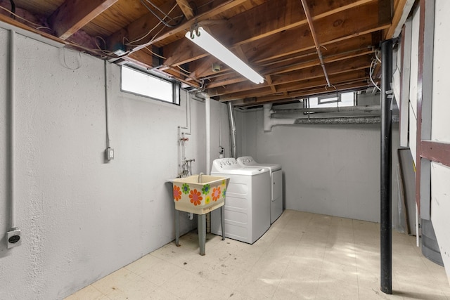 below grade area with a sink, tile patterned floors, and washer and clothes dryer