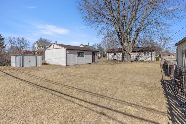 view of yard with a storage unit, an outdoor structure, and fence