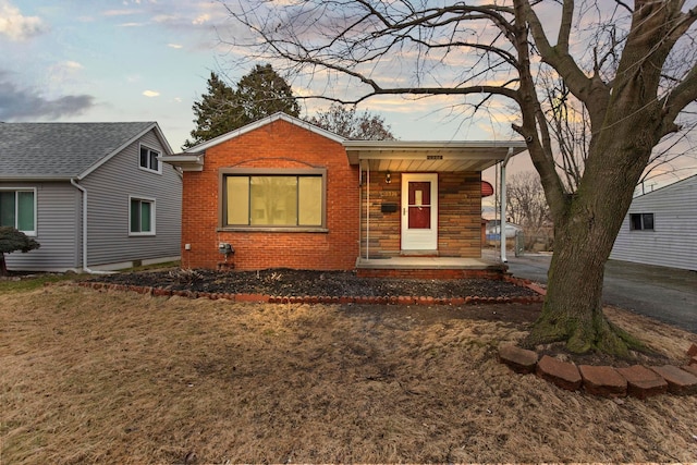 view of front of home featuring brick siding and a porch