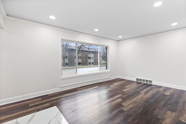 unfurnished room featuring visible vents, ornamental molding, and wood finished floors