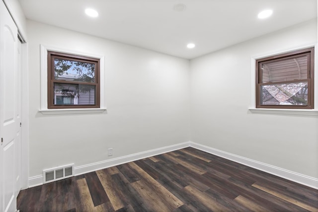 spare room featuring recessed lighting, visible vents, baseboards, and dark wood-style flooring