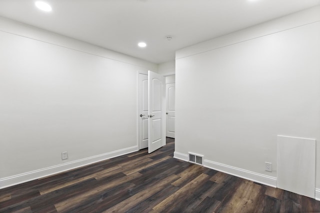 empty room with recessed lighting, visible vents, baseboards, and dark wood-style floors