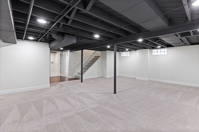 basement with carpet flooring, stairs, and baseboards