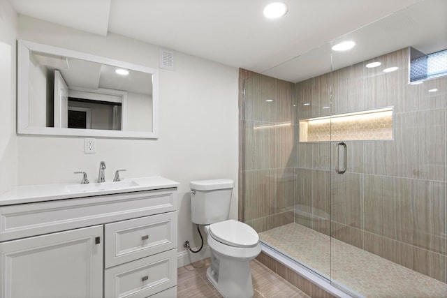 bathroom with vanity, visible vents, tiled shower, recessed lighting, and toilet