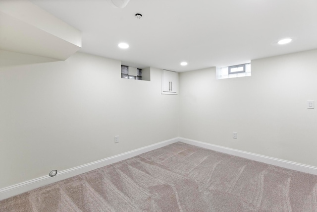 below grade area featuring recessed lighting, light colored carpet, and baseboards