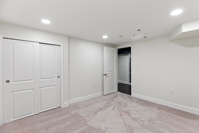 unfurnished bedroom featuring light carpet, recessed lighting, a closet, and baseboards