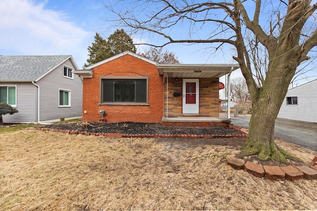 view of front of home with brick siding and a porch