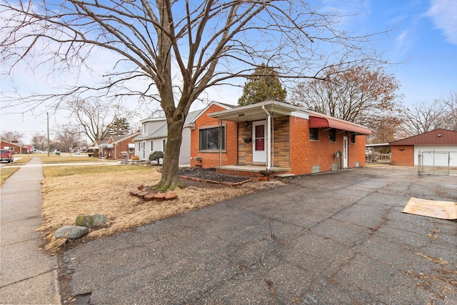 view of front of property featuring an outdoor structure, a garage, and brick siding