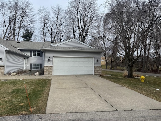 view of front of property with brick siding, roof with shingles, a front yard, a garage, and driveway