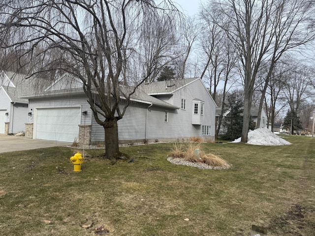 view of side of home with a garage, a yard, driveway, and a shingled roof