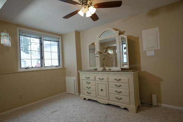 unfurnished bedroom featuring light carpet, a textured ceiling, a ceiling fan, and baseboards