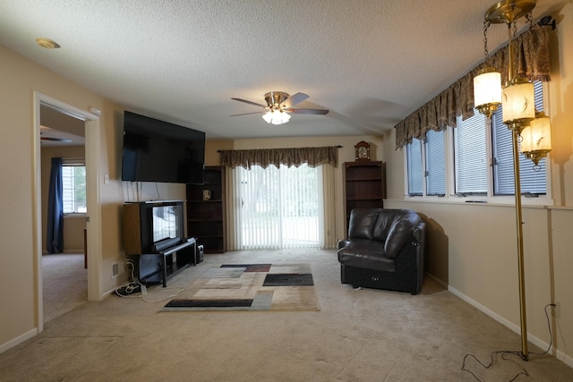 unfurnished living room with plenty of natural light, carpet, a ceiling fan, and a textured ceiling