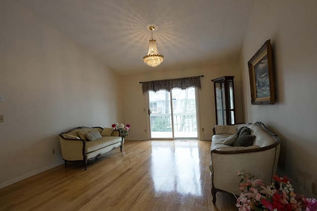 living area featuring light wood finished floors, baseboards, and vaulted ceiling