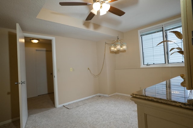 unfurnished room featuring light carpet, a textured ceiling, and baseboards