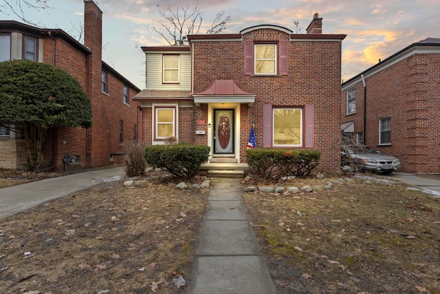 traditional-style home featuring brick siding and a chimney