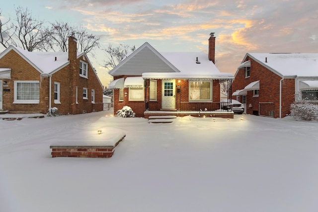 view of front of house featuring brick siding and a chimney