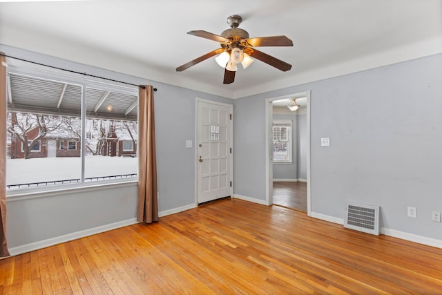 spare room with visible vents, a ceiling fan, light wood-type flooring, and baseboards