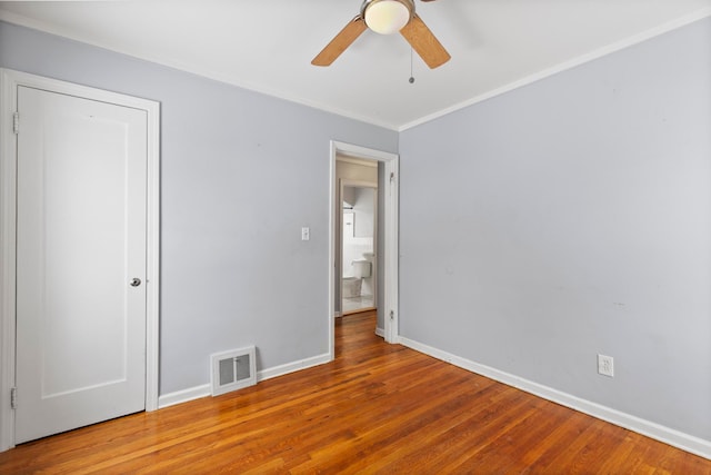 unfurnished bedroom featuring visible vents, ceiling fan, baseboards, ornamental molding, and wood finished floors