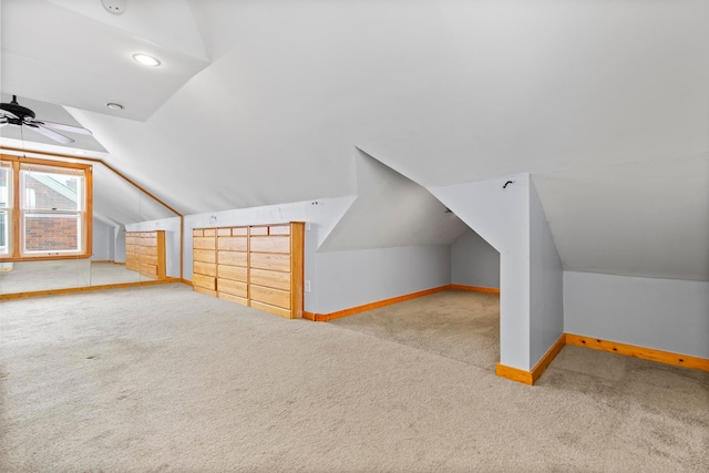 additional living space featuring baseboards, carpet, lofted ceiling, and a ceiling fan