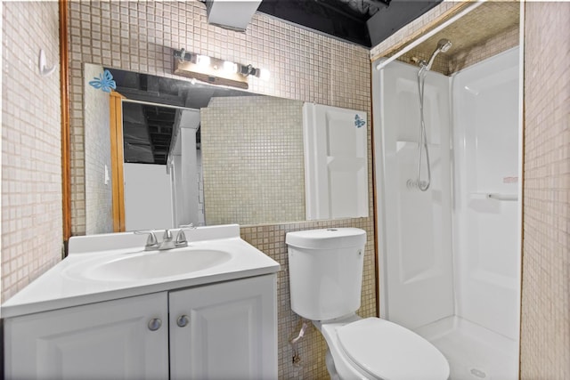 full bathroom with vanity, a shower stall, toilet, and tile walls