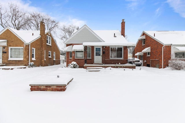 bungalow-style home with brick siding and a chimney