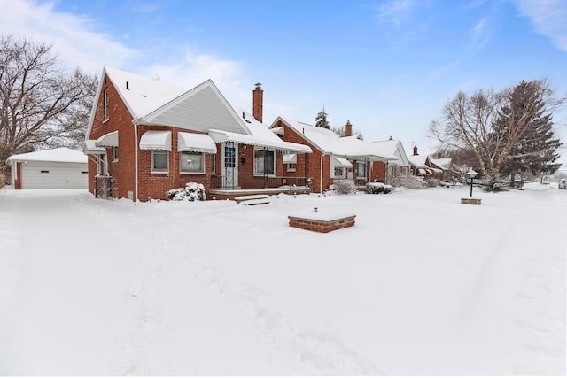 view of front of house with an outbuilding, a garage, a chimney, and brick siding