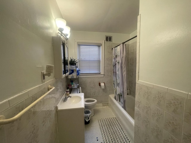 bathroom with visible vents, toilet, shower / bath combo with shower curtain, and tile walls