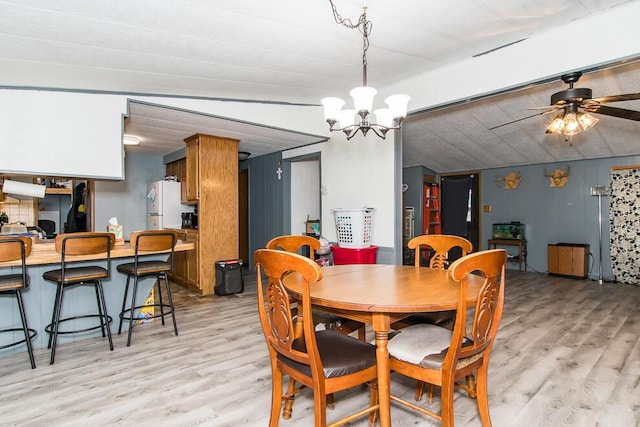 dining room with light wood-style floors and ceiling fan with notable chandelier