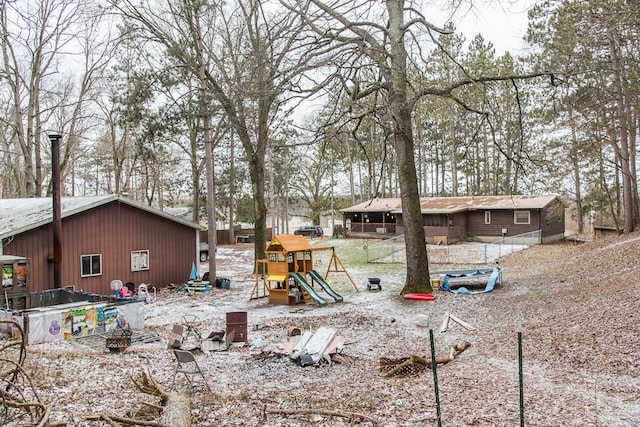 view of front of home with fence and a playground