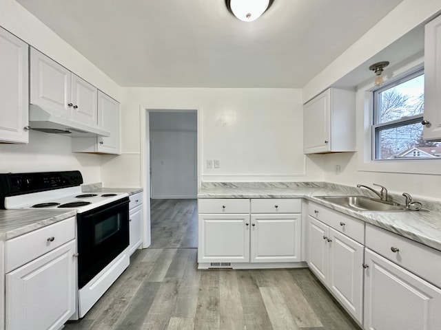 kitchen with light wood finished floors, electric range, white cabinetry, a sink, and under cabinet range hood