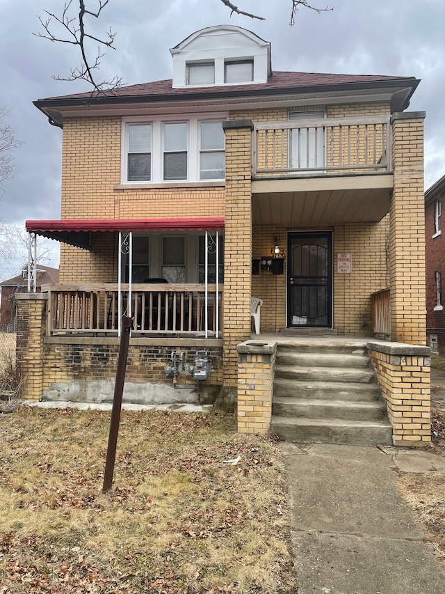 view of front of house with a porch and brick siding