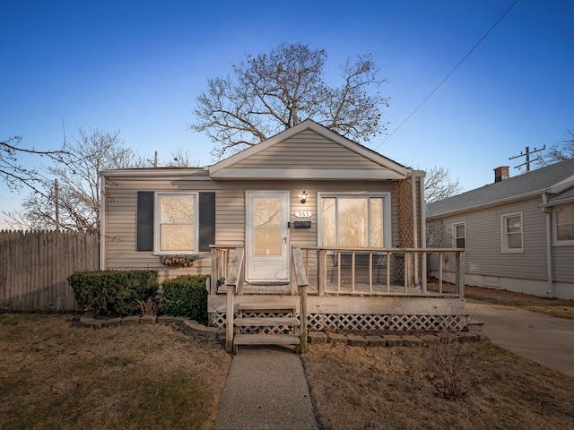 view of front of home with a deck and fence