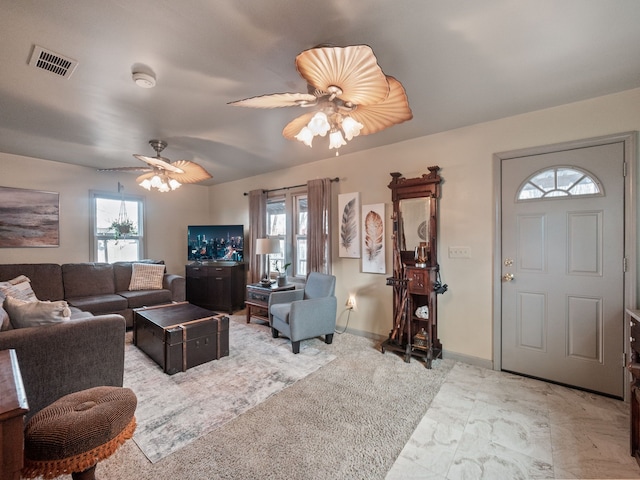 living room with visible vents, baseboards, and a ceiling fan