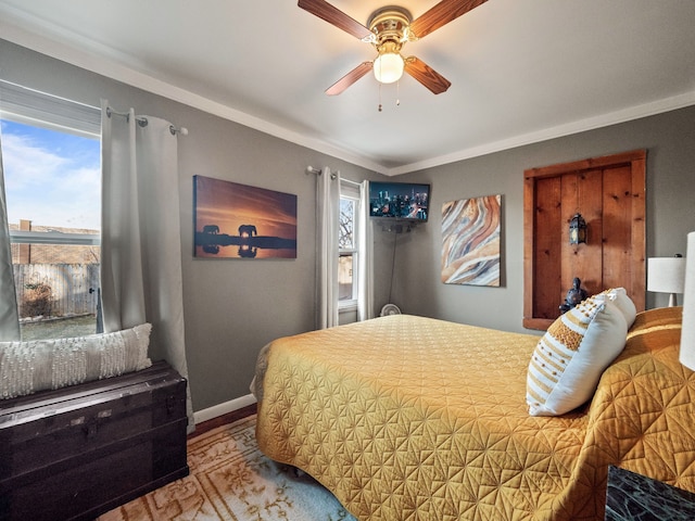 bedroom with baseboards, ceiling fan, and crown molding