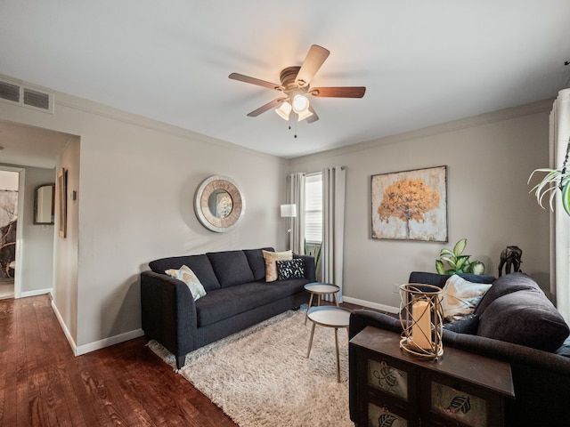 living area featuring visible vents, baseboards, dark wood-type flooring, and a ceiling fan