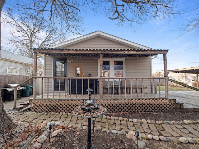 rear view of house with fence and covered porch