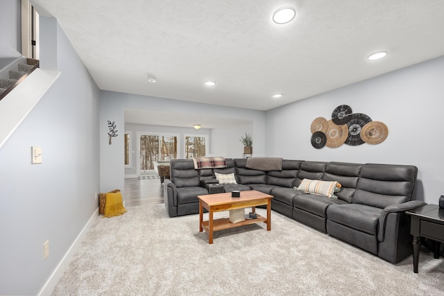 carpeted living area with recessed lighting, a textured ceiling, baseboards, and stairs