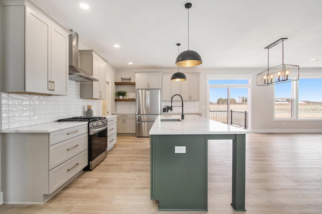 kitchen with stainless steel appliances, a sink, wall chimney range hood, light wood-type flooring, and open shelves