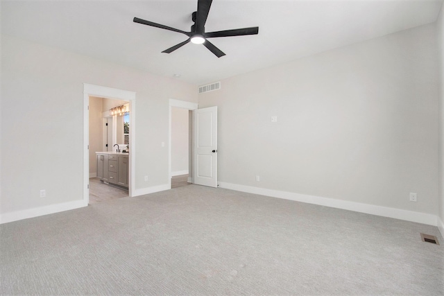 unfurnished bedroom featuring light colored carpet, visible vents, connected bathroom, and baseboards