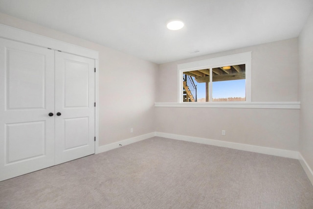 unfurnished bedroom featuring a closet, carpet flooring, and baseboards