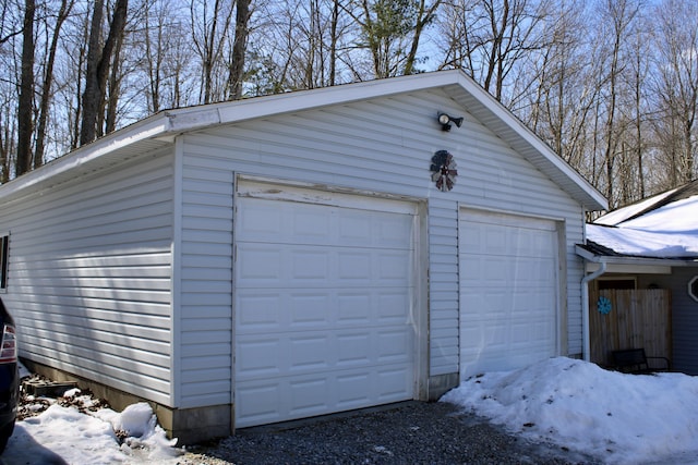 snow covered garage featuring a detached garage