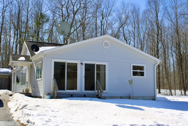 view of snow covered back of property