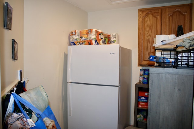 kitchen with freestanding refrigerator and brown cabinets