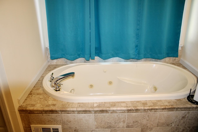 bathroom featuring a jetted tub and visible vents