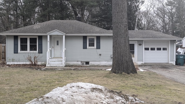 view of front of property featuring a front yard, roof with shingles, driveway, and an attached garage