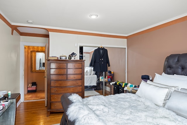 bedroom featuring crown molding and wood finished floors