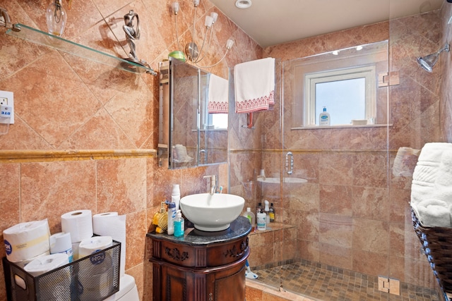 full bathroom with tiled shower, tile walls, and vanity