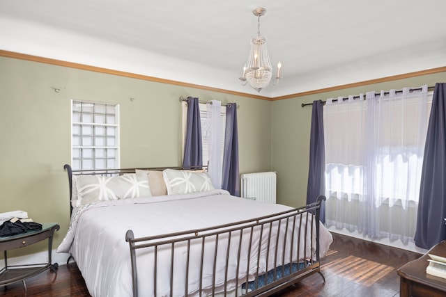 bedroom with radiator, a chandelier, and wood finished floors